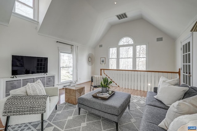 living area with visible vents, a healthy amount of sunlight, and wood finished floors