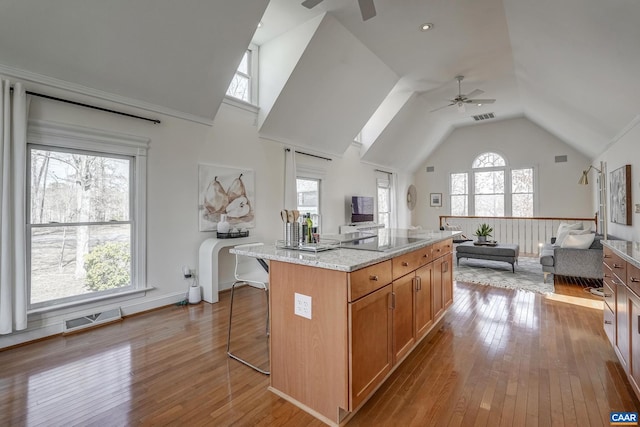 kitchen featuring visible vents, hardwood / wood-style flooring, open floor plan, and black electric cooktop