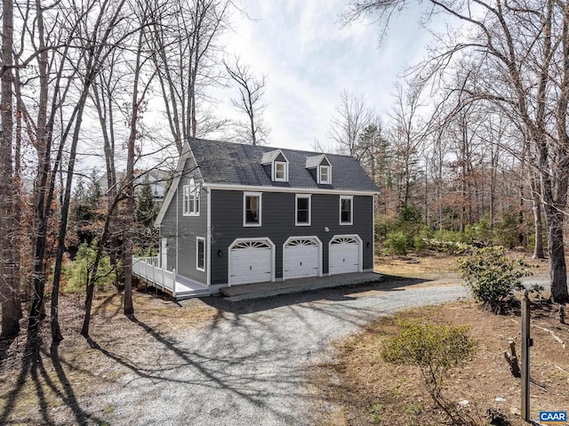 view of front of home featuring a garage and roof with shingles