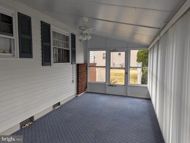 unfurnished sunroom featuring a ceiling fan and vaulted ceiling