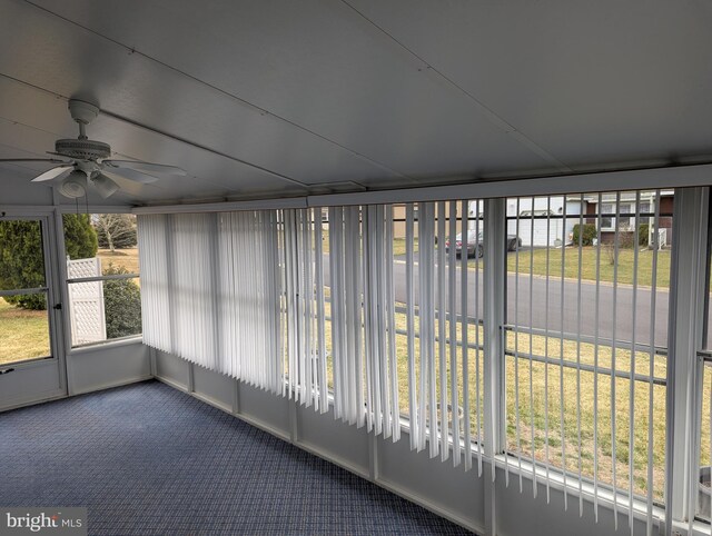 unfurnished sunroom with ceiling fan