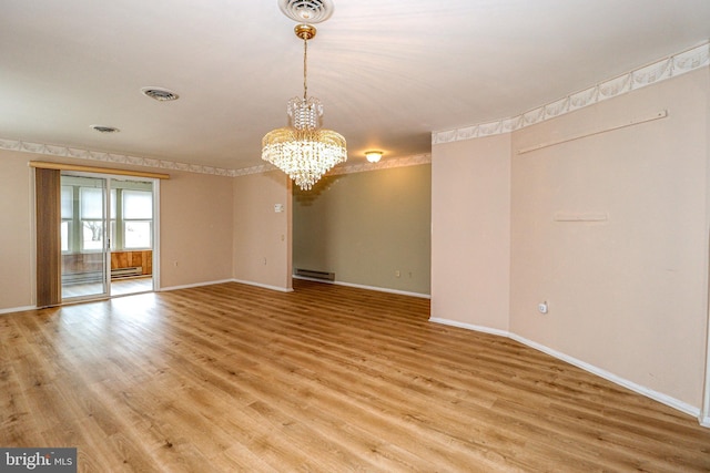 empty room featuring visible vents, a notable chandelier, and light wood-style flooring