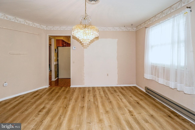 unfurnished dining area featuring a notable chandelier, a baseboard heating unit, baseboards, and wood finished floors