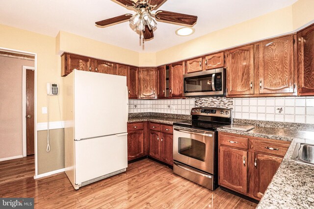 kitchen featuring decorative backsplash, ceiling fan, stainless steel appliances, and light wood-style floors