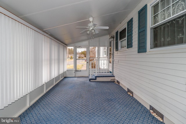 unfurnished sunroom featuring vaulted ceiling and a ceiling fan