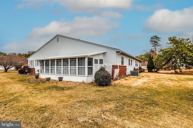 back of house with a yard, central AC unit, and a sunroom