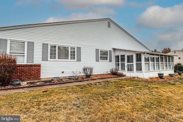 back of house with a lawn and a sunroom