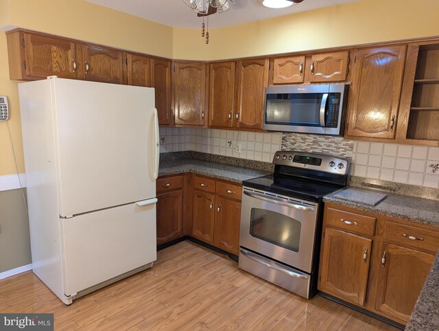 kitchen with stainless steel appliances, brown cabinets, and light wood-style floors