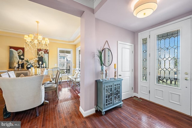 entrance foyer with baseboards, a notable chandelier, dark wood-style floors, and crown molding