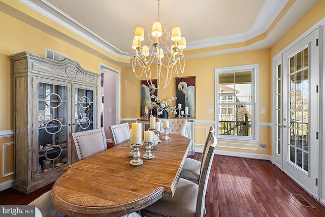 dining room featuring visible vents, french doors, a notable chandelier, a raised ceiling, and wood-type flooring