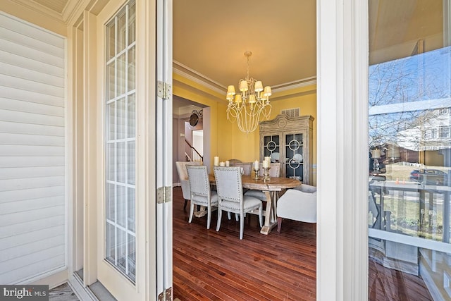 dining area featuring a chandelier, wood finished floors, and ornamental molding