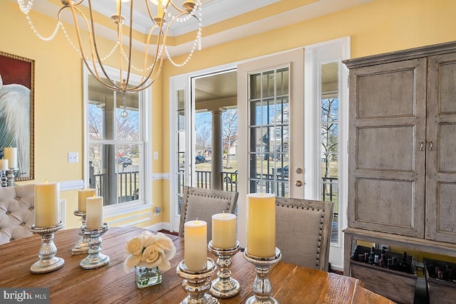 dining area featuring crown molding, a raised ceiling, and a chandelier