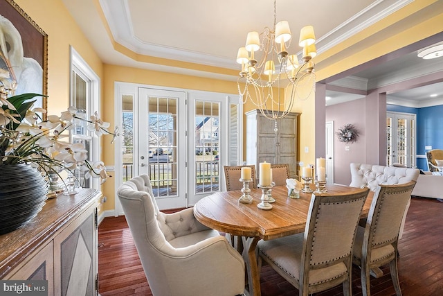 dining room with a tray ceiling, dark wood-style flooring, french doors, crown molding, and a notable chandelier