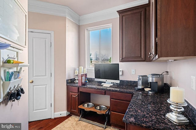 home office with built in study area, crown molding, baseboards, and wood finished floors