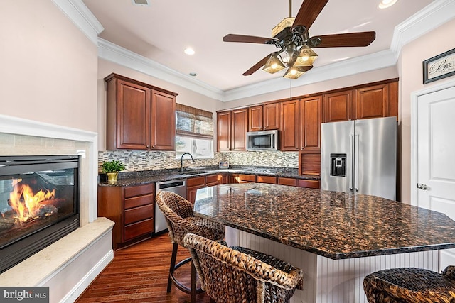 kitchen featuring a sink, tasteful backsplash, appliances with stainless steel finishes, and ornamental molding