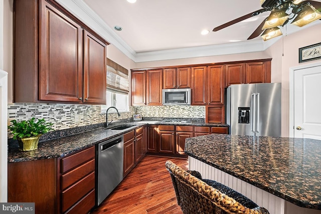 kitchen with a sink, decorative backsplash, ornamental molding, dark wood-type flooring, and stainless steel appliances