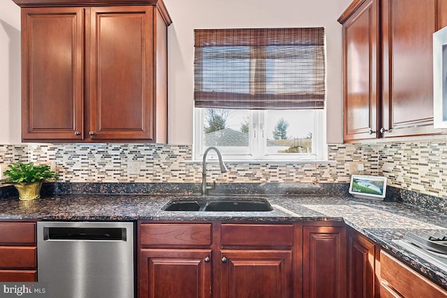 kitchen with a sink, tasteful backsplash, appliances with stainless steel finishes, and dark stone countertops