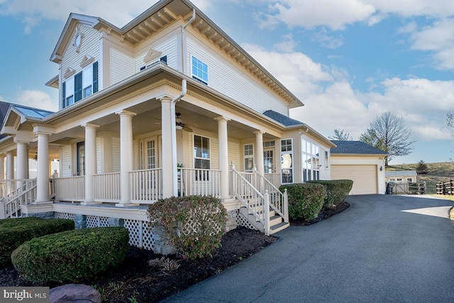 view of front of home featuring ceiling fan, a garage, covered porch, and an outdoor structure