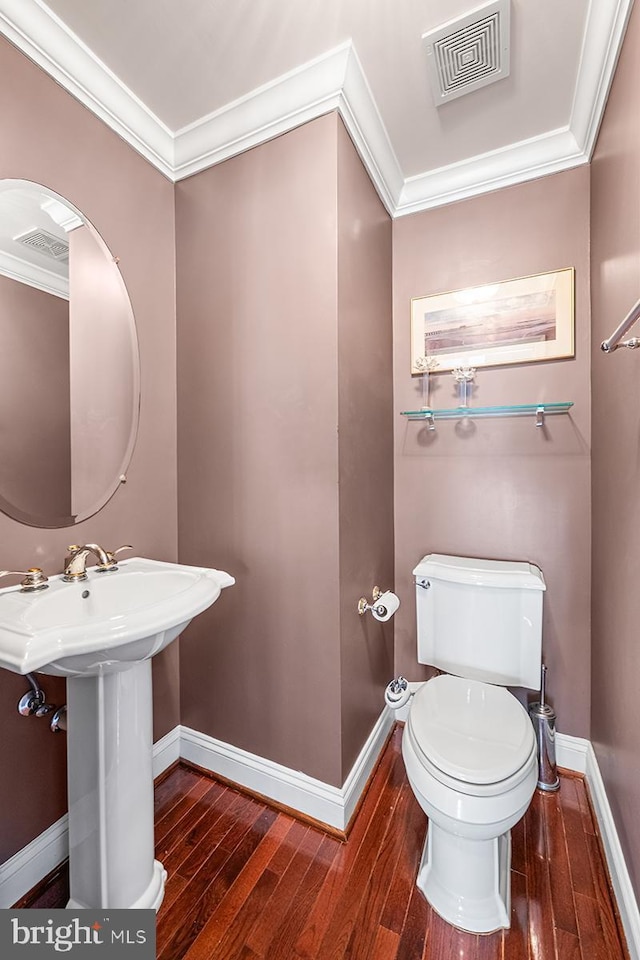 half bath with baseboards, visible vents, and ornamental molding