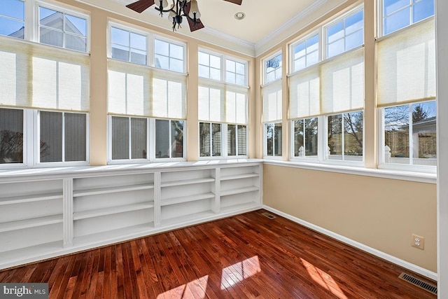 unfurnished sunroom featuring a ceiling fan, visible vents, and a wealth of natural light