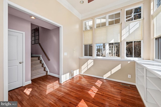 foyer entrance with wood finished floors, baseboards, visible vents, stairs, and crown molding