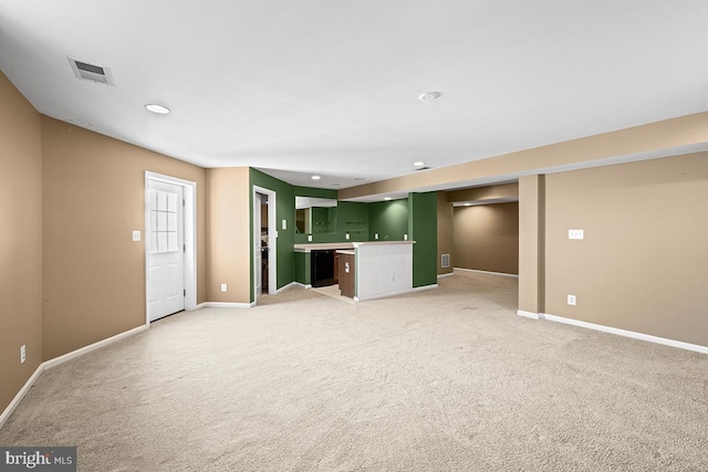 unfurnished living room featuring visible vents, light carpet, bar area, and baseboards