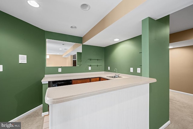 kitchen with baseboards, light colored carpet, dishwasher, light countertops, and a sink