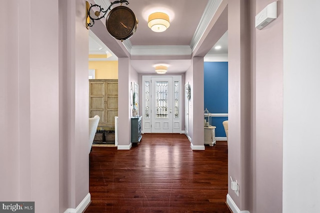 foyer featuring a tray ceiling, dark wood-style floors, baseboards, and ornamental molding