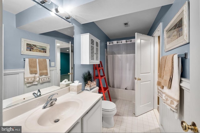 bathroom featuring a wainscoted wall, toilet, shower / bath combo, tile patterned flooring, and vanity