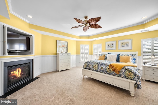 bedroom with a wainscoted wall, visible vents, a fireplace with flush hearth, and carpet floors