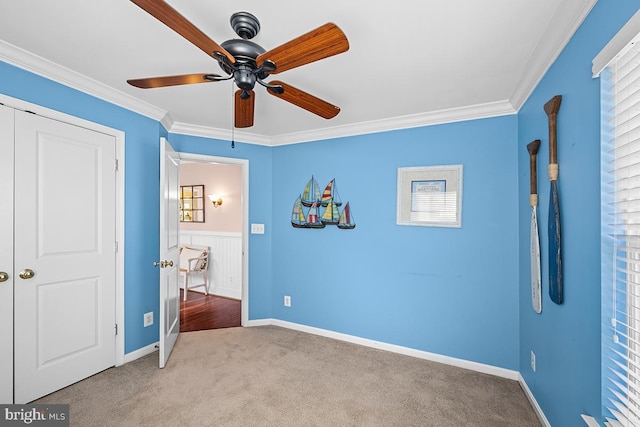 unfurnished bedroom featuring carpet flooring, ceiling fan, and crown molding