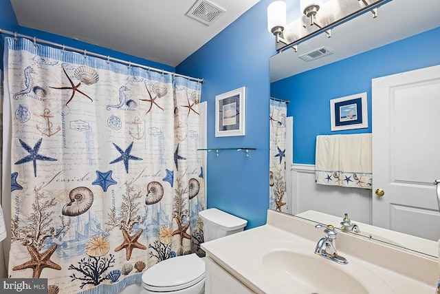 full bathroom featuring visible vents, vanity, toilet, and wainscoting