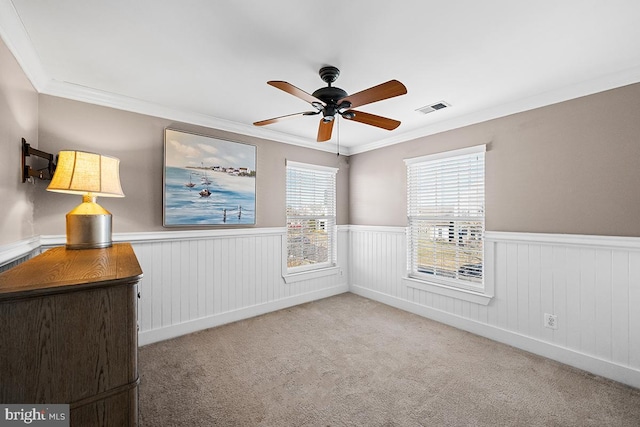 unfurnished room featuring visible vents, carpet, and a wainscoted wall