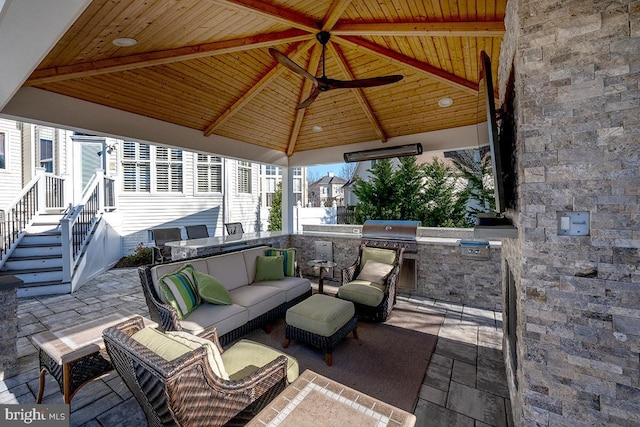 view of patio with a gazebo, area for grilling, an outdoor living space, and exterior kitchen