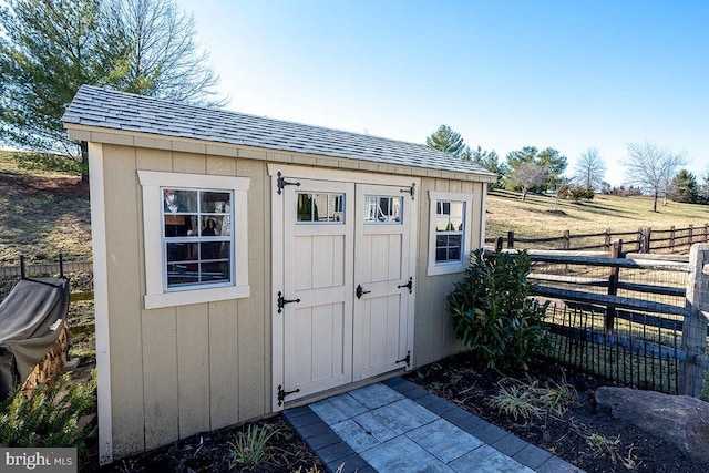 view of shed featuring fence