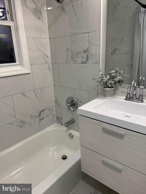 bathroom featuring marble finish floor, shower / bath combo, and vanity