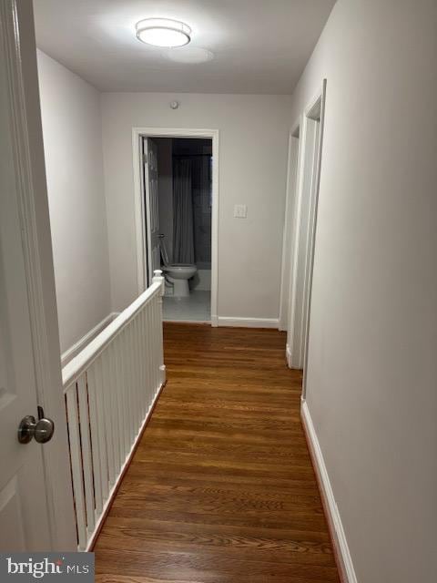 hall featuring baseboards and wood finished floors