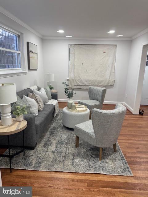 living area with recessed lighting, baseboards, wood finished floors, and ornamental molding