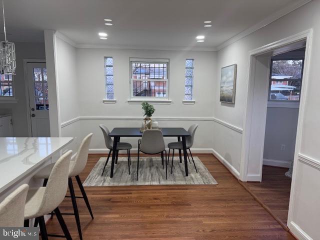 dining room featuring crown molding, recessed lighting, wood finished floors, and baseboards