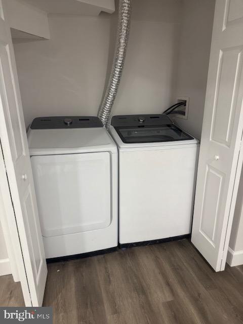 clothes washing area featuring dark wood-style floors, laundry area, and independent washer and dryer