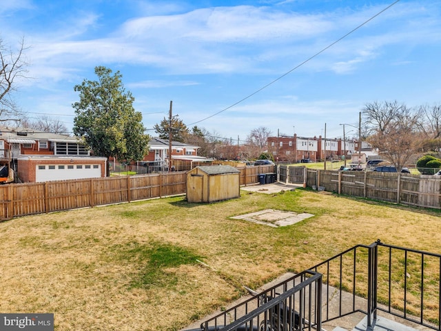 view of yard featuring a storage shed, an outdoor structure, a fenced backyard, and a residential view