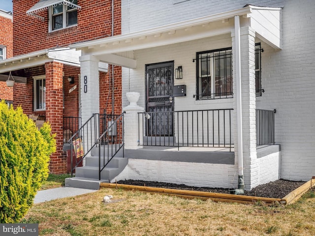 property entrance featuring brick siding and covered porch