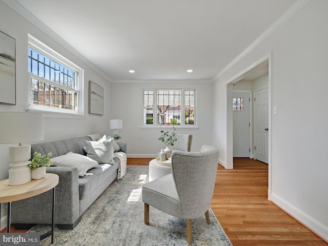 living room featuring a wealth of natural light, wood finished floors, and ornamental molding