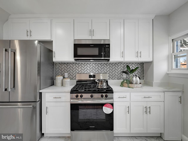 kitchen with backsplash, light countertops, stainless steel appliances, marble finish floor, and white cabinetry