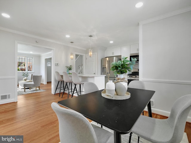 dining area with light wood-type flooring, visible vents, ornamental molding, and recessed lighting