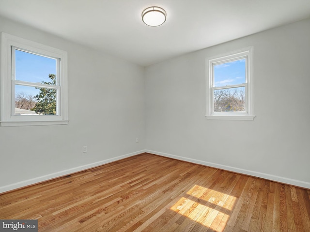 unfurnished room with baseboards and wood finished floors