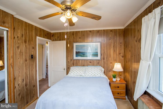 bedroom featuring carpet flooring, ceiling fan, wooden walls, and ornamental molding