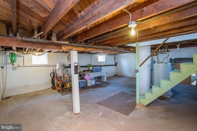 basement featuring stairs, gas water heater, and plenty of natural light