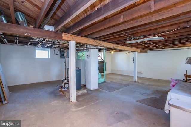 basement featuring electric panel and water heater