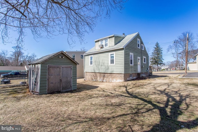 rear view of property with a storage unit, an outbuilding, and a lawn